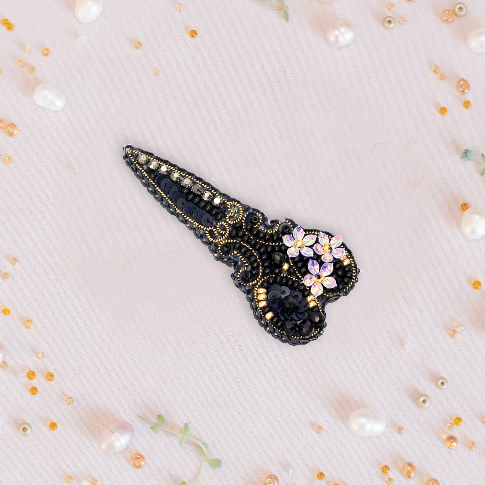 a black and gold brooch with flowers on it